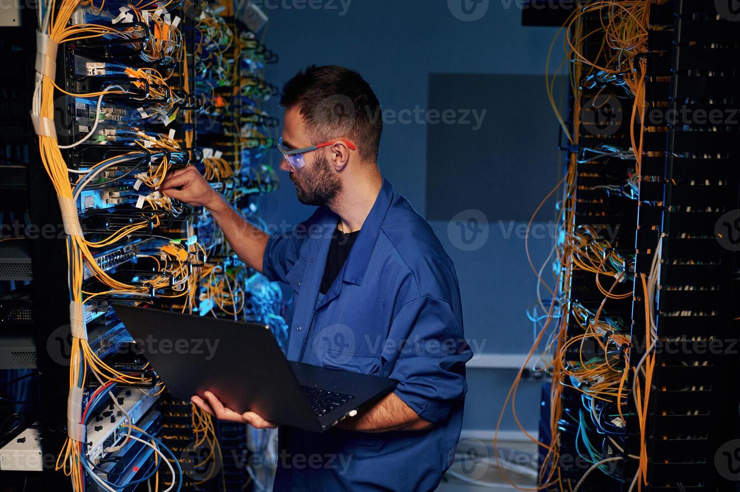 Repairman is busy and, working with internet equipment and wires in server room photo