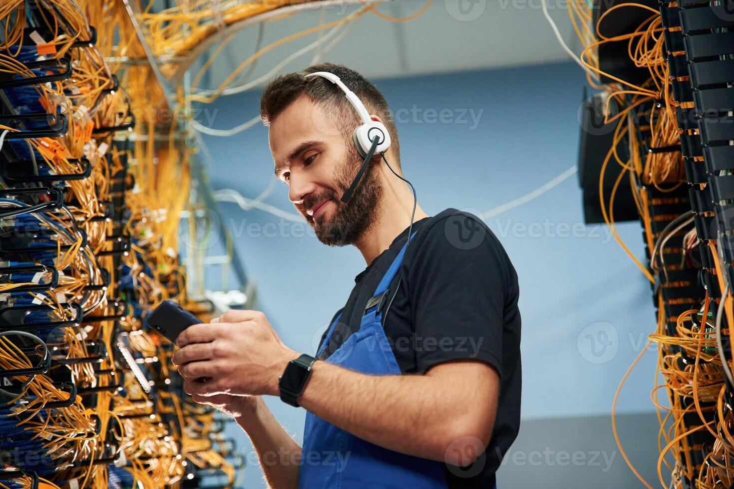 Young man is working ,with internet equipment and wires in server room photo