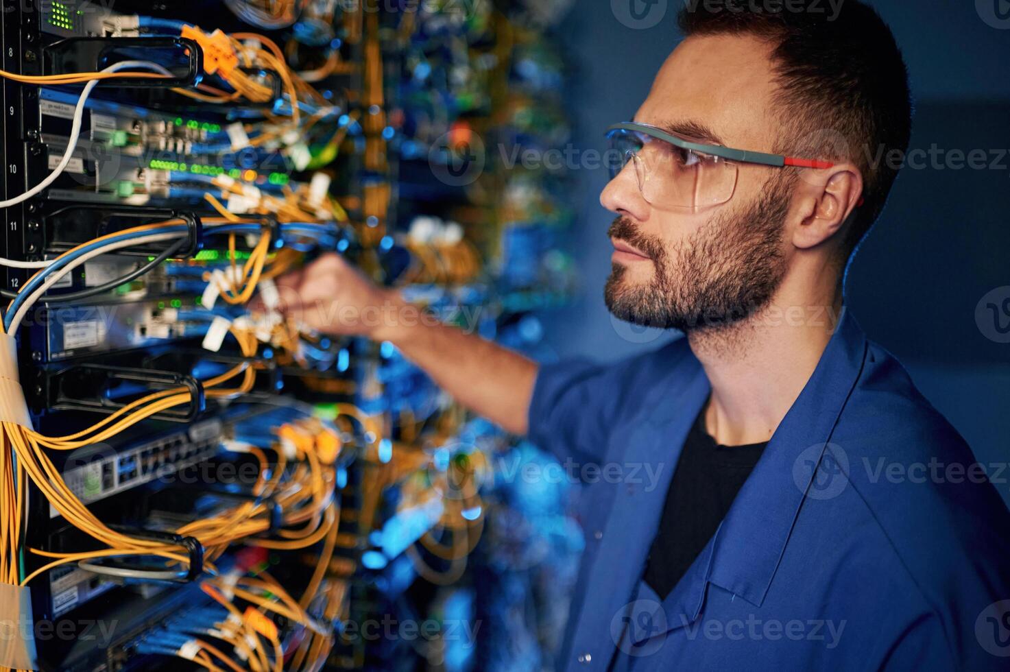Repairman, is busy and working with internet equipment and wires in server room photo