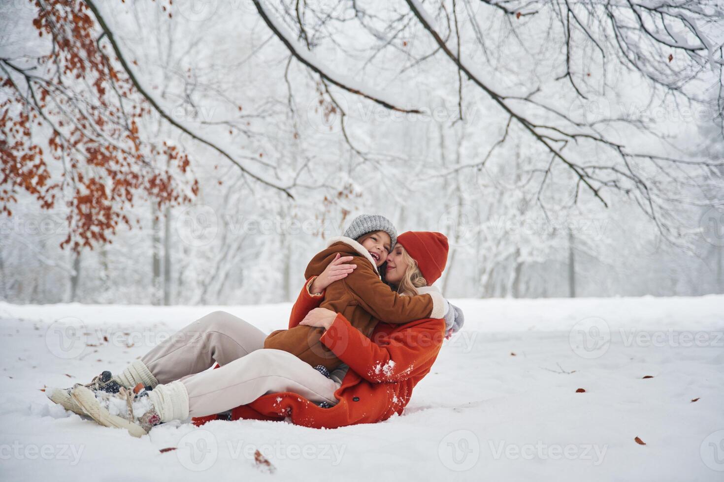 Embracing each, other. Mother ,and her ,daughter is on the winter meadow and forest photo