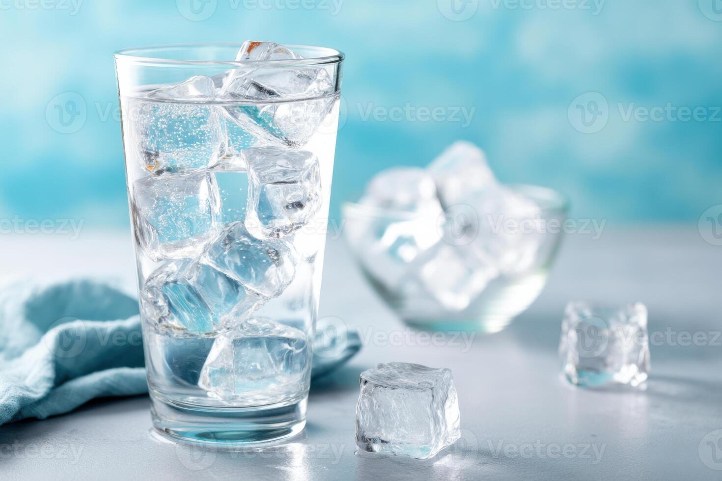 Refreshing glass of ice water with clear ice cubes on a light surface and a blue background, perfect for hydration and summer drinks, healthy lifestyle concept photo