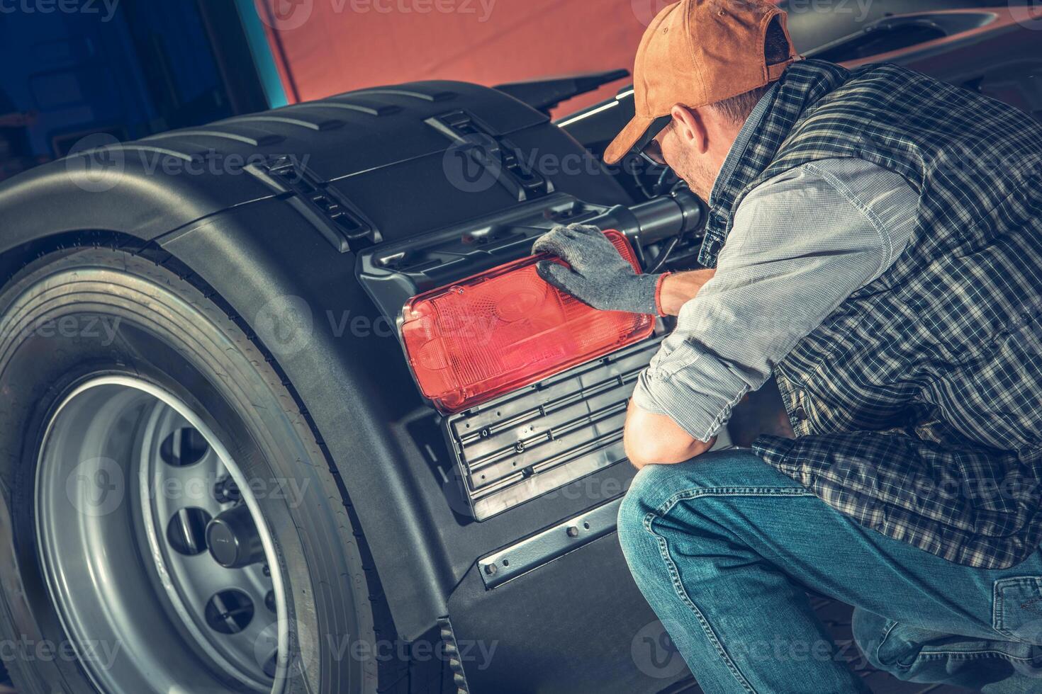 Truck Mechanic Repairing Truck Rear Light in Workshop During Daytime photo