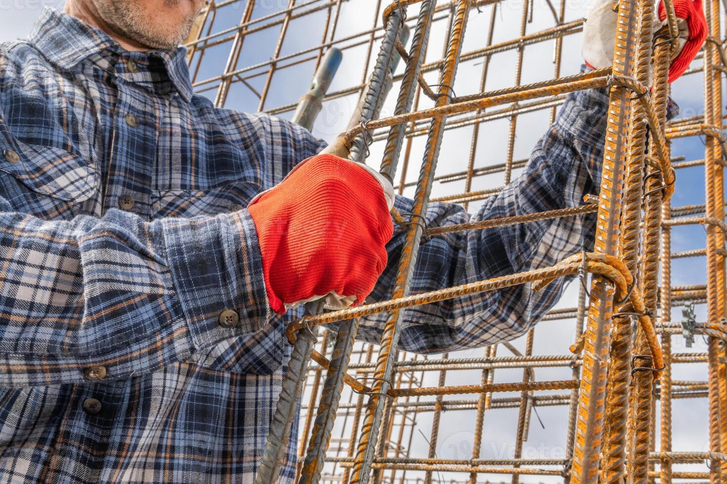 Construction Worker Assembling Steel Reinforcements on Site photo
