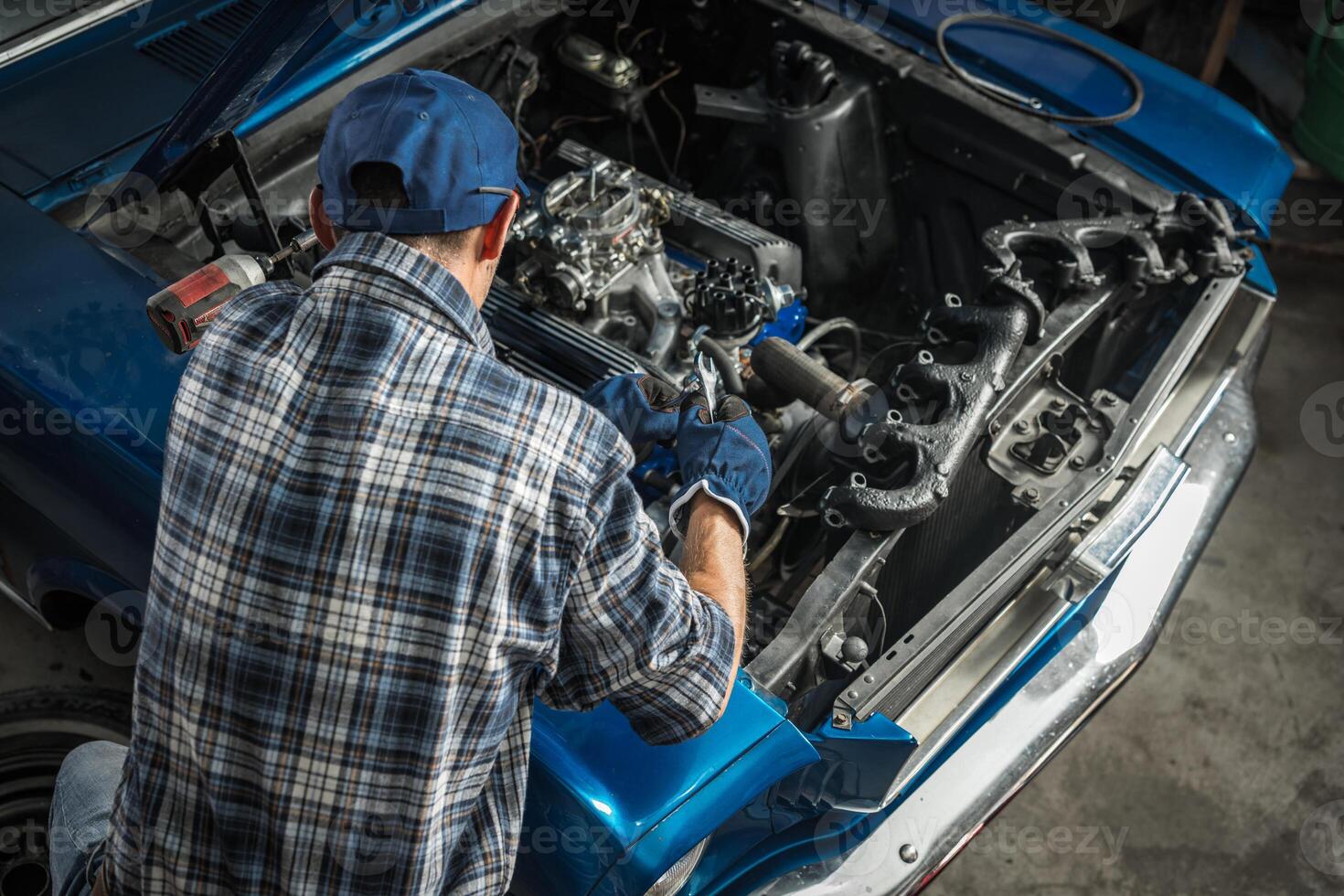 Car Mechanic Repairing Engine in Automotive Workshop photo