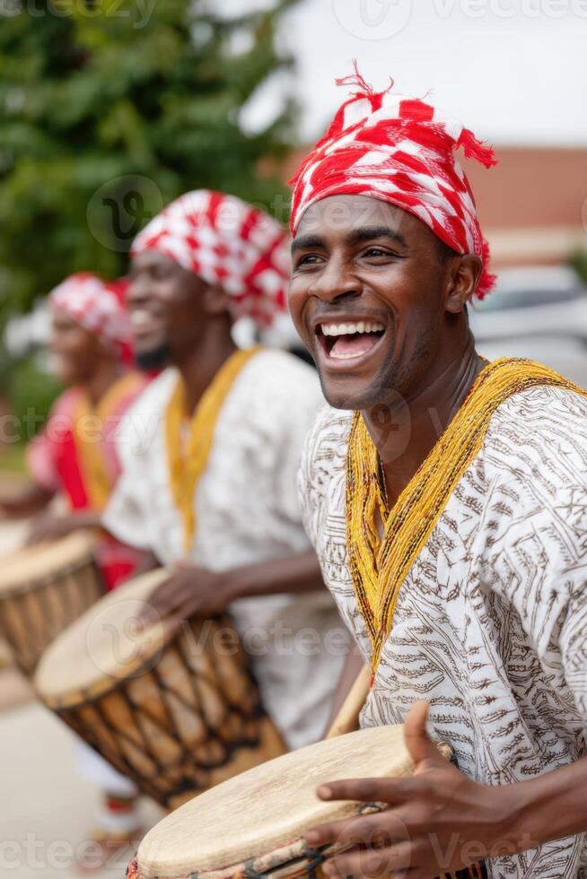 Group of african drummers wearing traditional clothes playing djembe drums and smiling photo