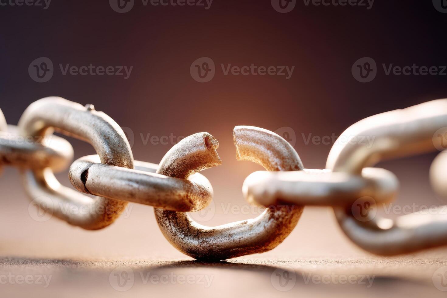 Broken metal chain on brown background representing broken promises and lost friendships photo