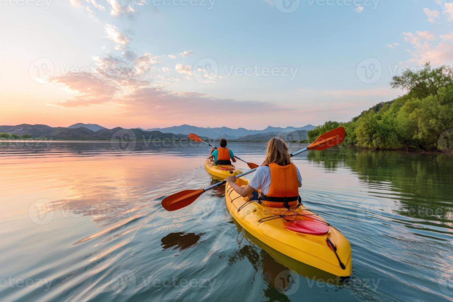Tourists kayaking on lake at sunset enjoying summer vacation photo