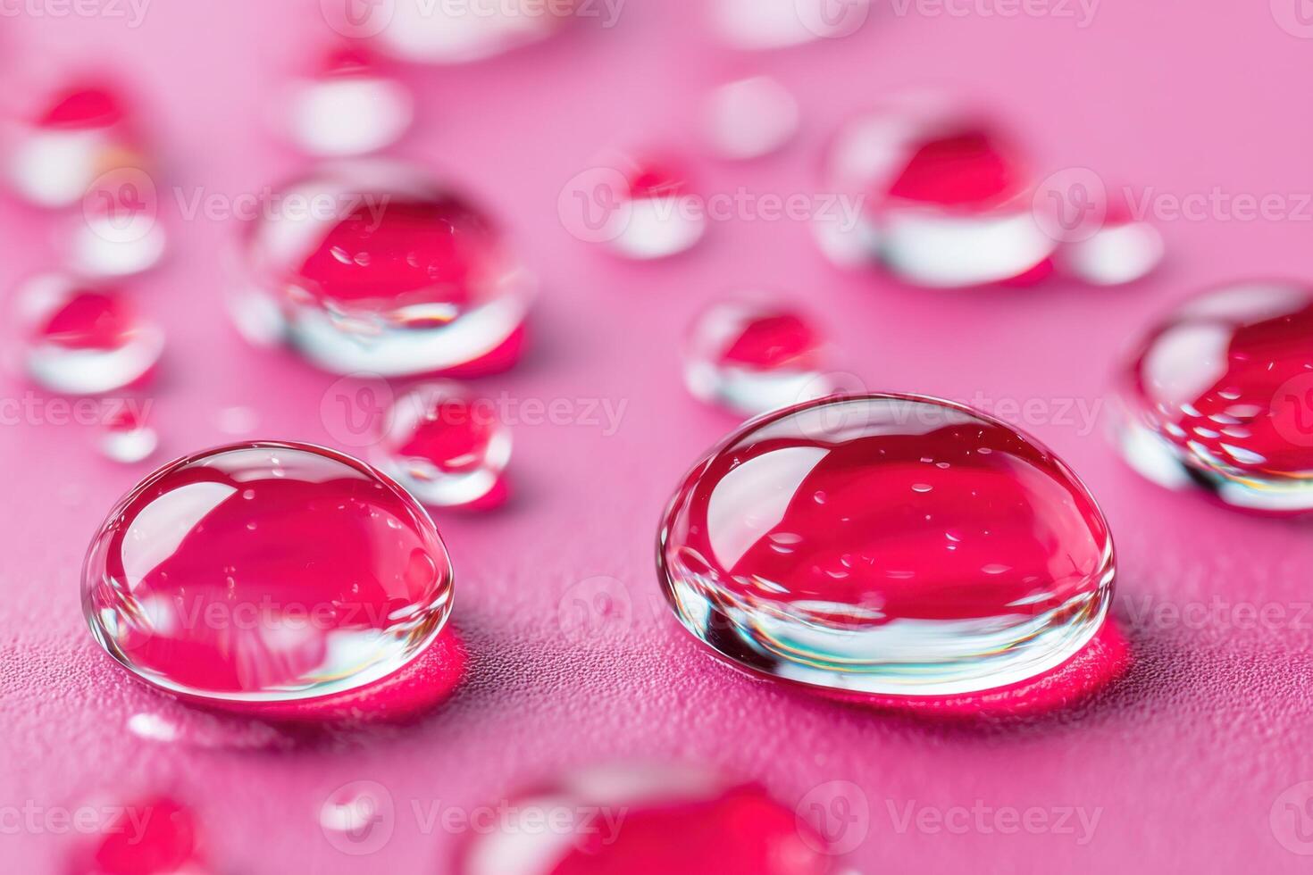 Macro water drops reflecting pink surface creating shiny beads photo