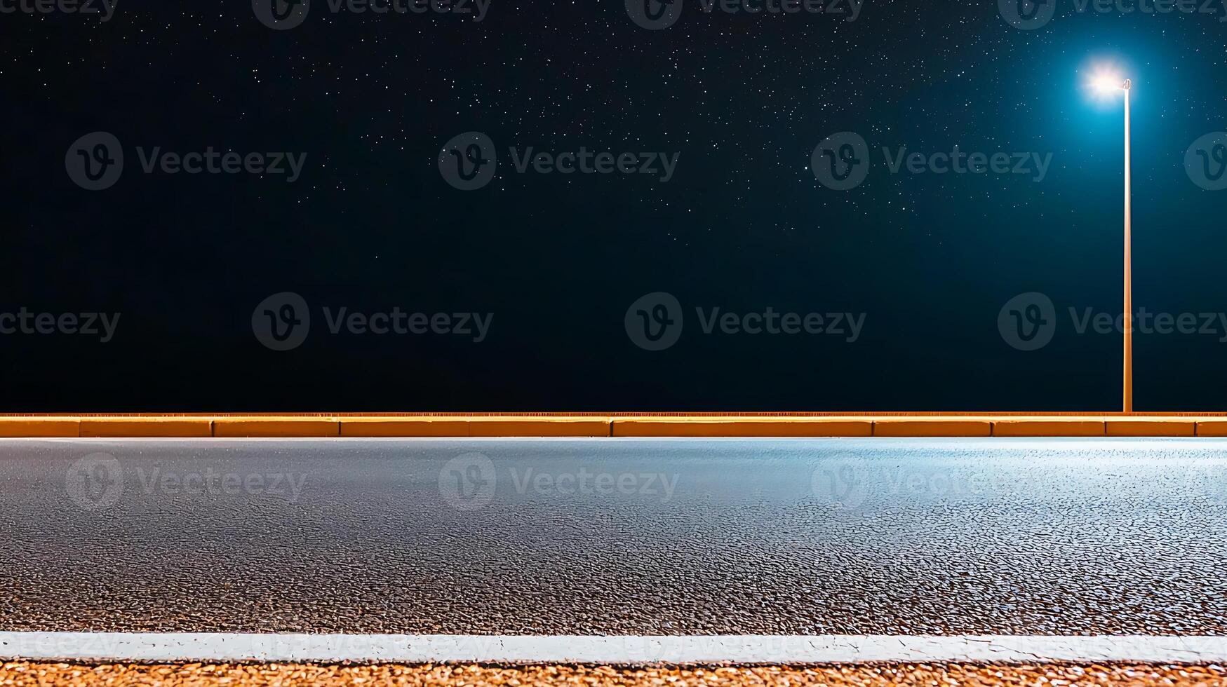 Nighttime highway scene with illuminated streetlight, clear road, and starry sky above photo