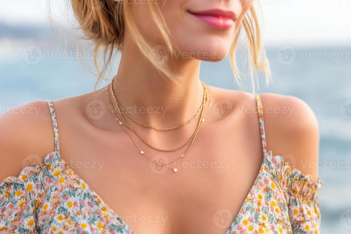 Woman wearing golden necklaces with heart shaped pendant enjoying summer vacation photo