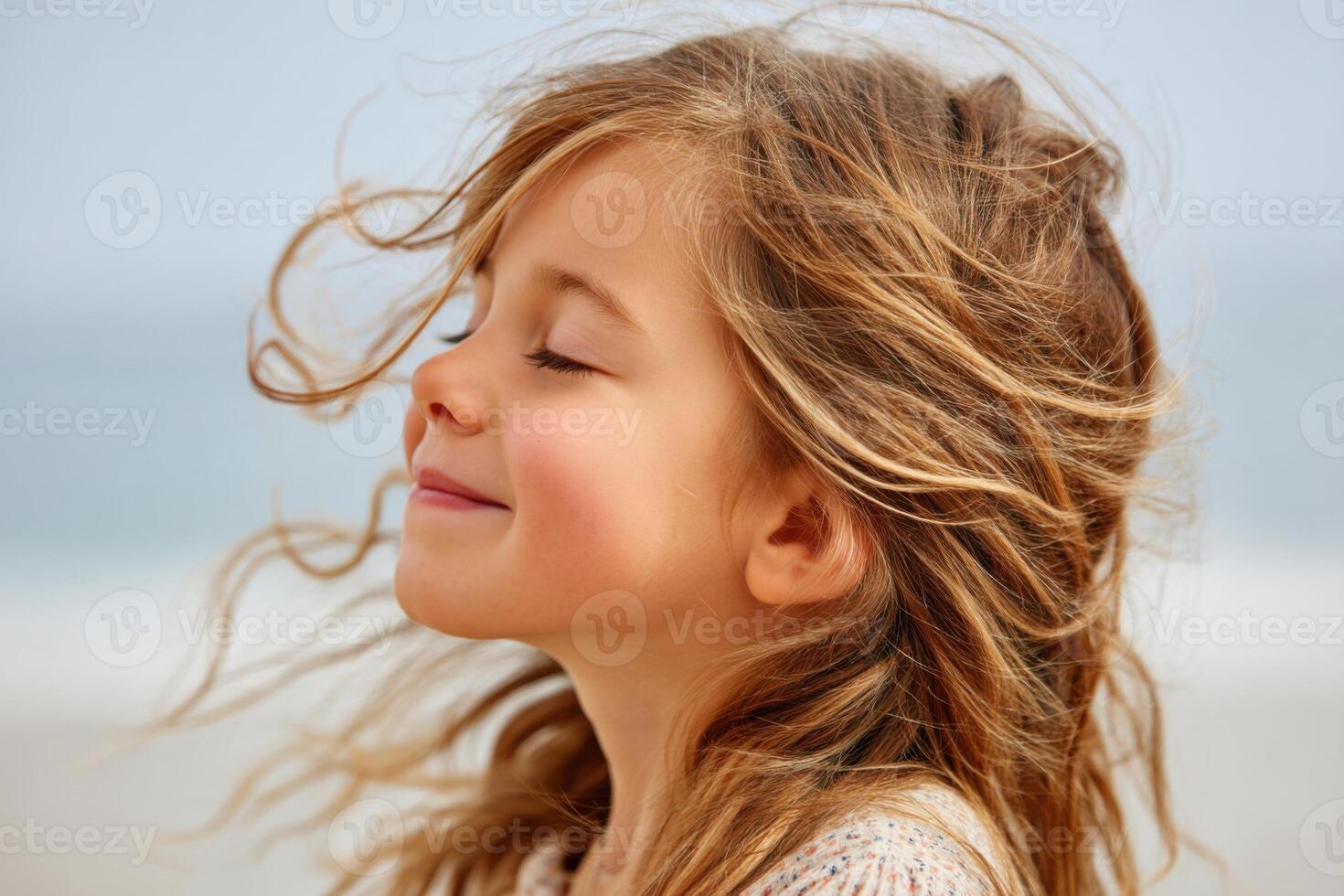 Young girl enjoying fresh air with closed eyes and smiling face photo