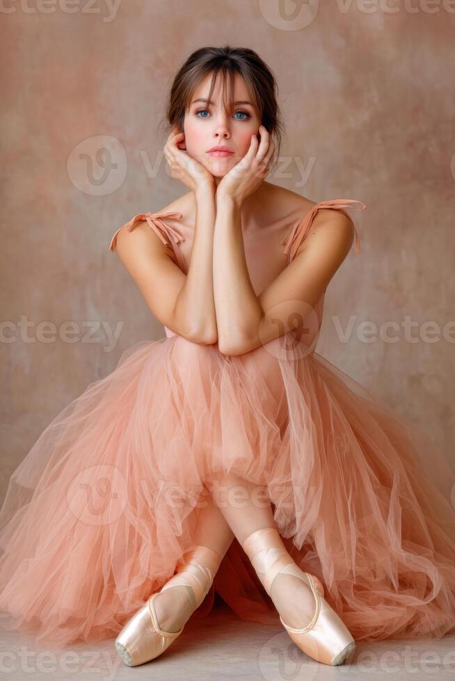 Ballerina resting on floor wearing tutu and pointe shoes photo
