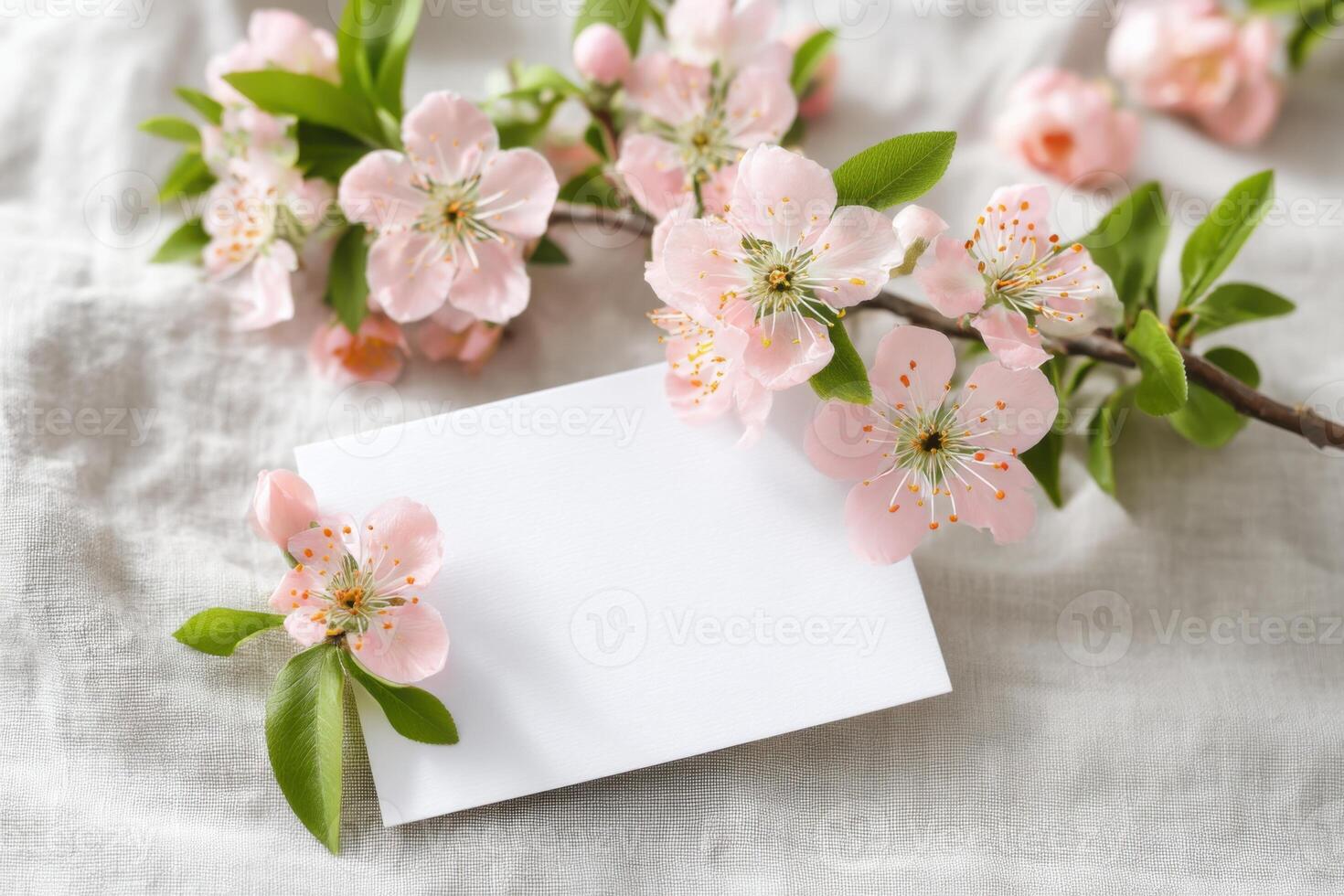 Blooming peach tree branch decorating invitation card on linen tablecloth photo