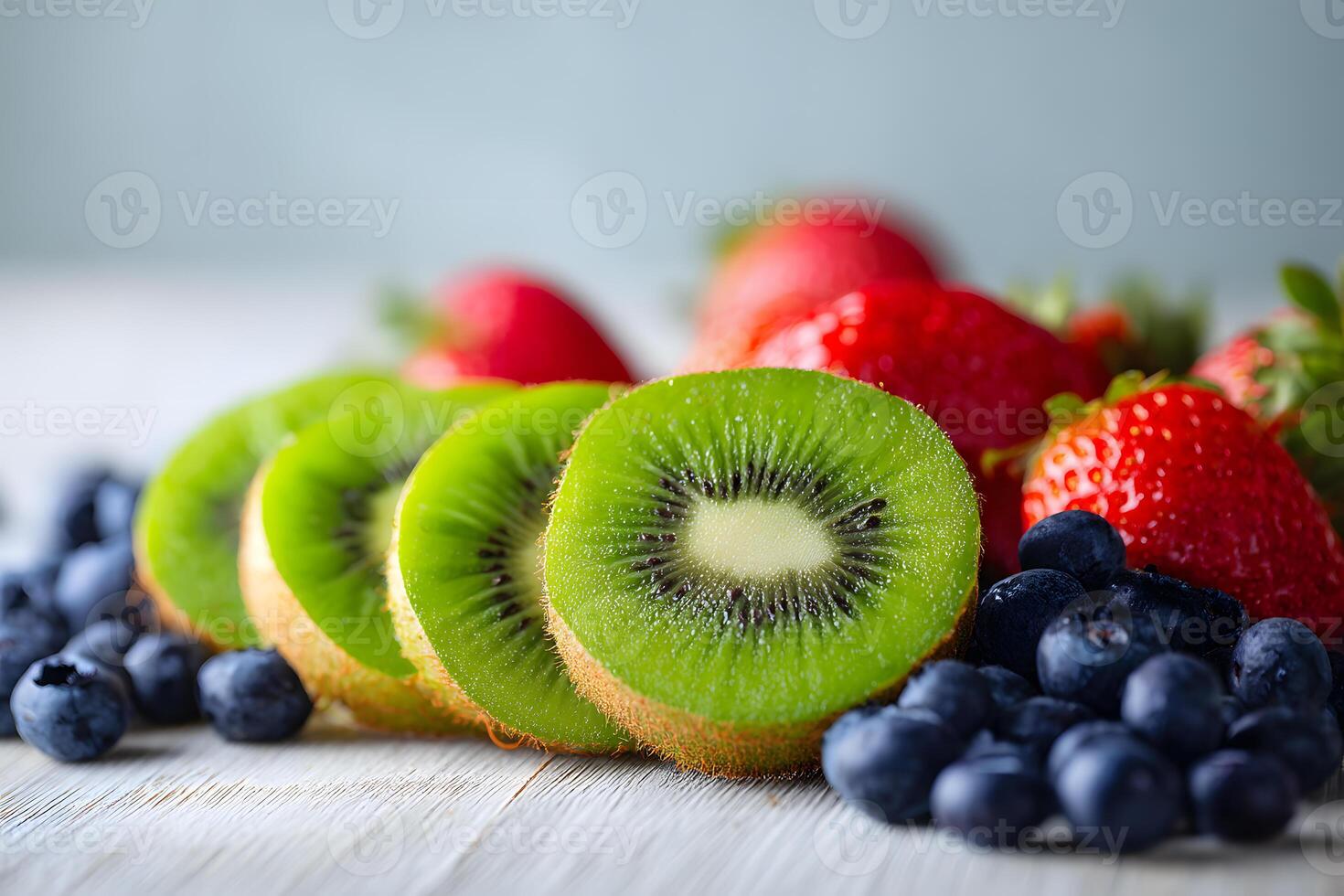 Artfully arranged slices of green kiwis paired with fresh blueberries and juicy strawberries for a refreshing snack. photo