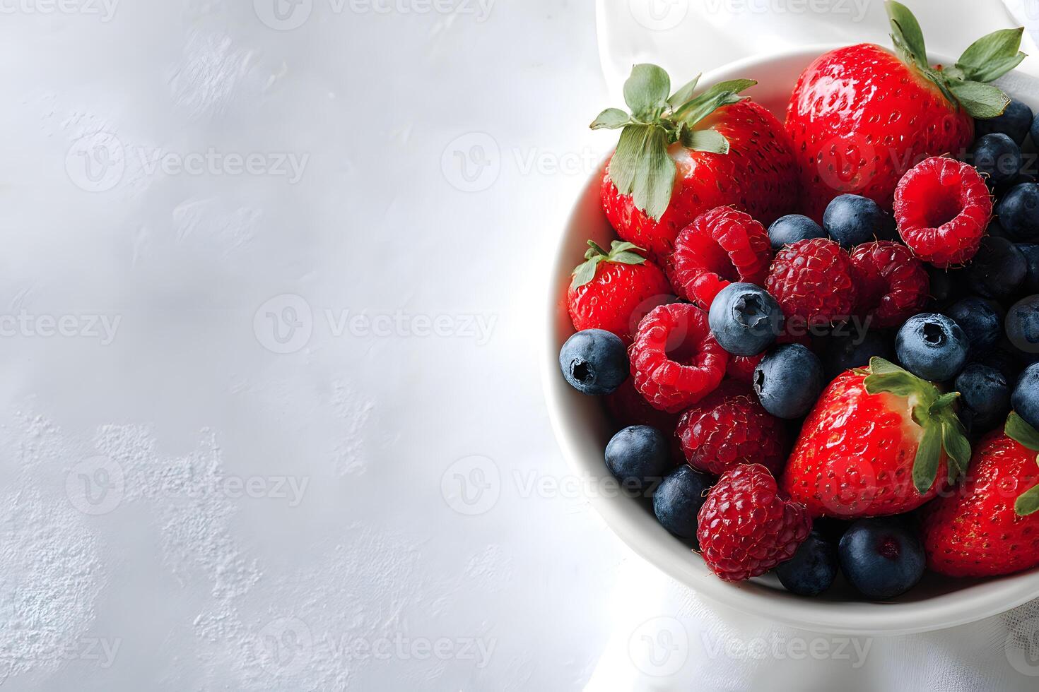 Bowl filled with a fresh selection of strawberries, blueberries, and raspberries. photo