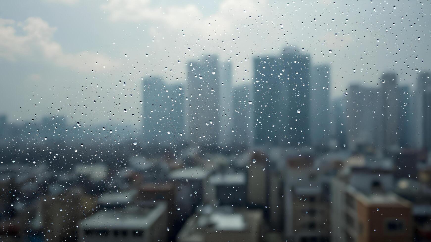 Raindrops on Window With Blurred Cityscape in Background photo