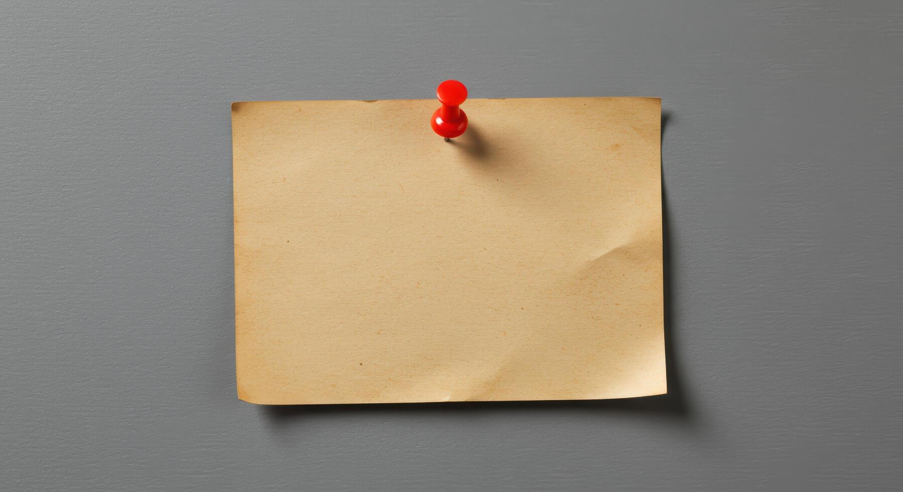 Blank vintage brown paper note pinned to gray wall, suitable for advertisements, announcements, reminders, or as a background for quotes or text overlays. photo