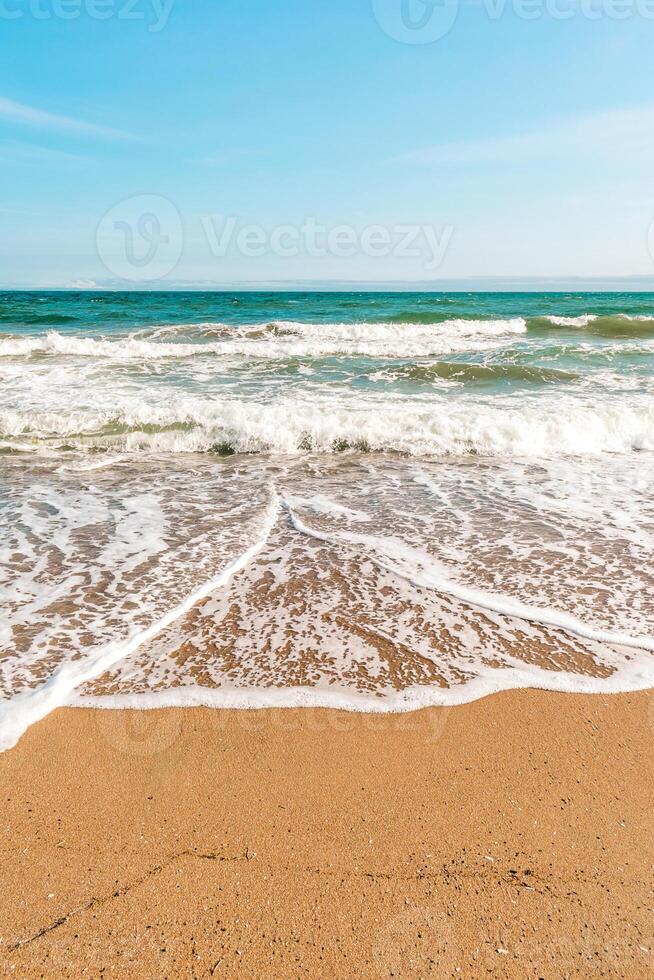 Background sea beach with waves and foam. Sandy beach and sea turquoise waves. Feeling of carelessness, enjoyment of freedom and happiness. photo