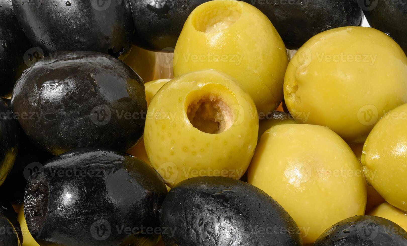 Detailed close up mix of smooth, pitted green and black olives, filling the frame photo