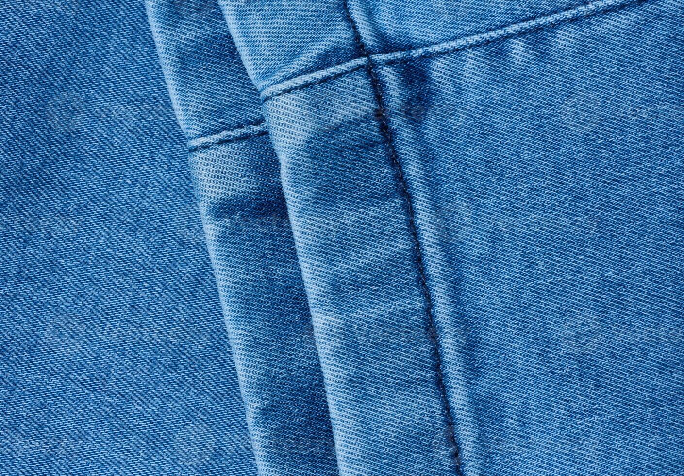 Fragment of the bottom of a pair of blue jeans with a decorative seam photo