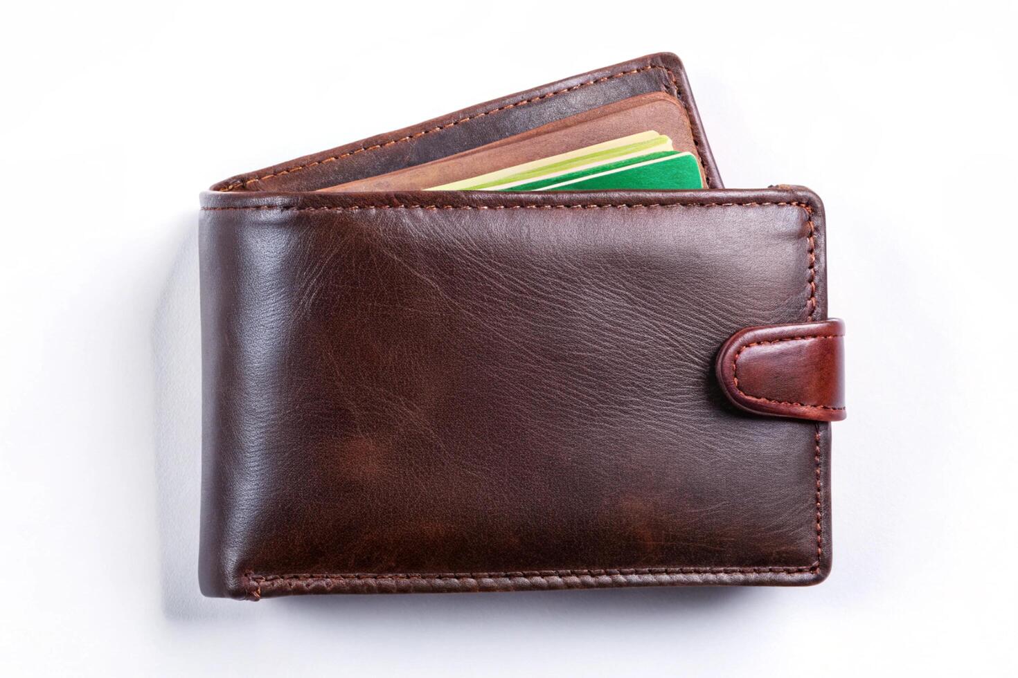 Stylish brown leather wallet with several cards and cash, neatly arranged on a clean white surface photo