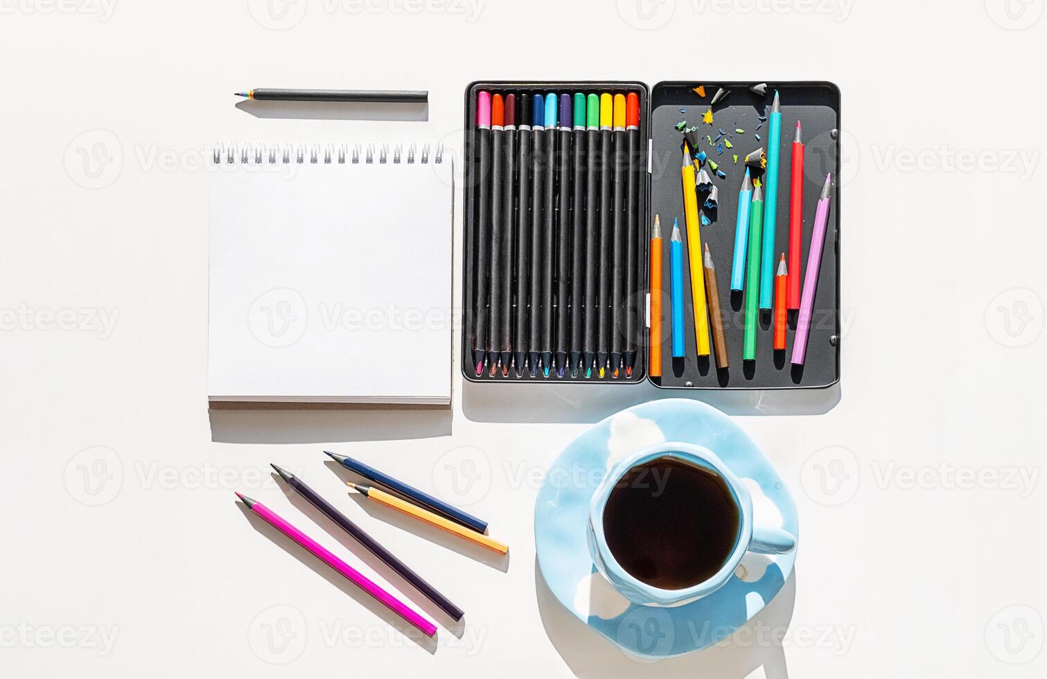 Artistic Workspace Arrangement with Open Colored Pencil Box and Sketchbook in Natural Light. Art Therapy for Relaxation. photo