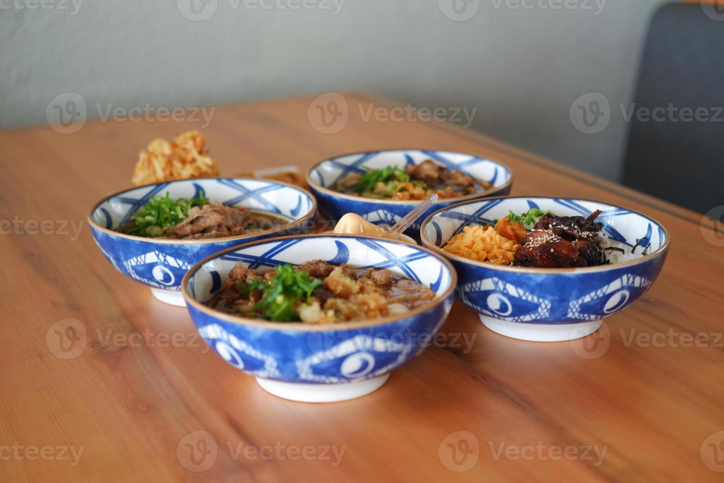 a beautiful assortment of Japanese rice and noodle bowls arranged neatly on a wooden table photo