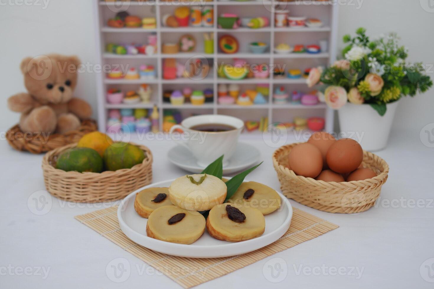 These soft, round cakes are garnished with raisins and pandan leaves, adding both flavor and visual appeal photo