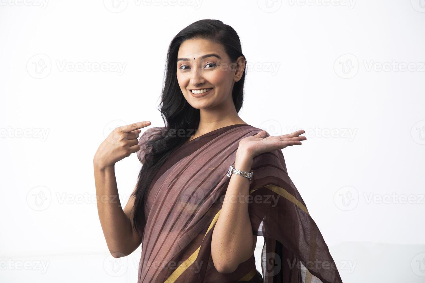 Positive Woman In Saree With Open Palm Pointing With Finger photo