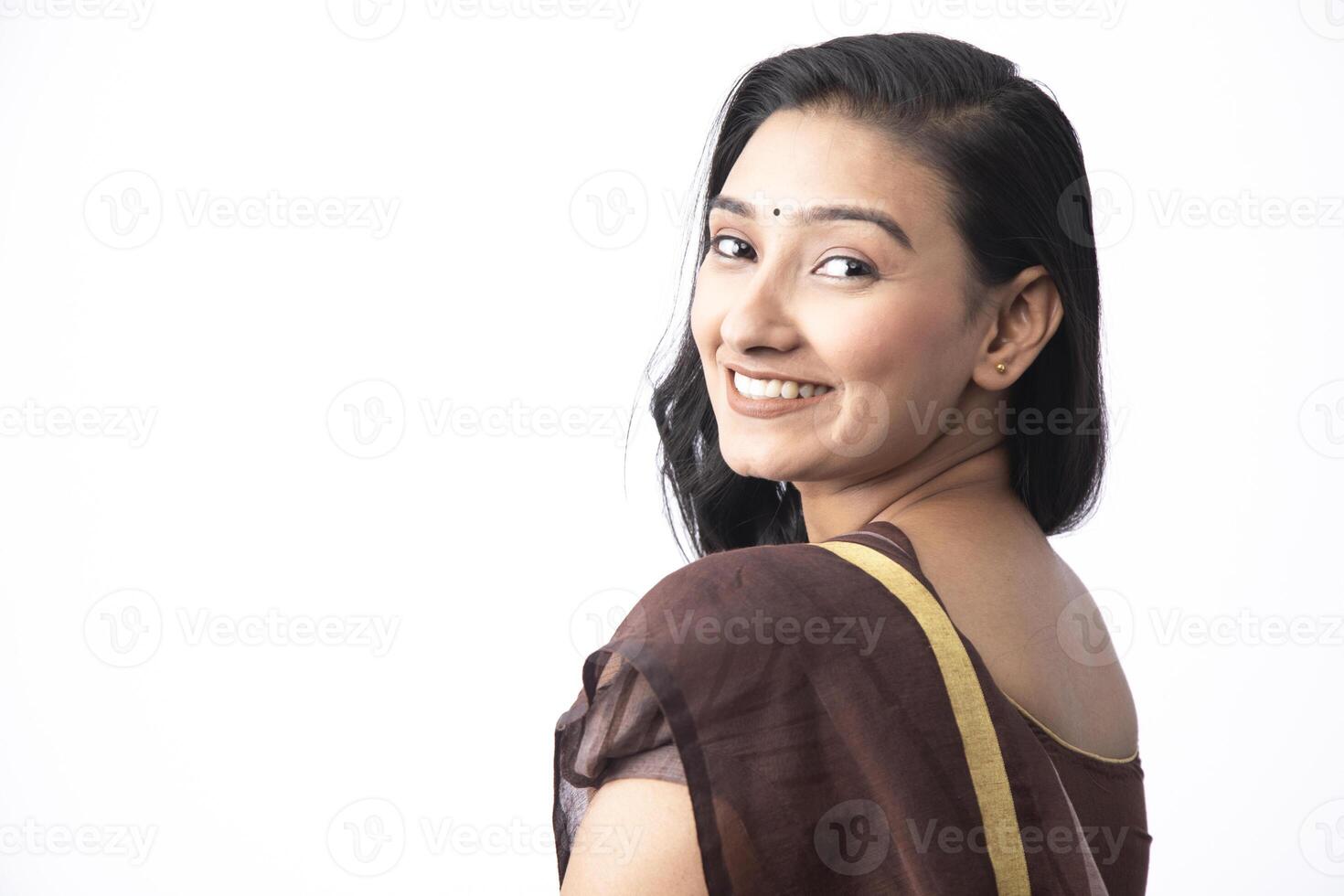 Young Model Smiling At The Camera While Wearing Sari And Standing In The Studio photo