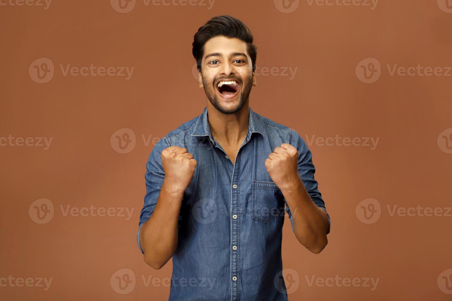 Indian male model is pumping his fists in joy and excitement. photo