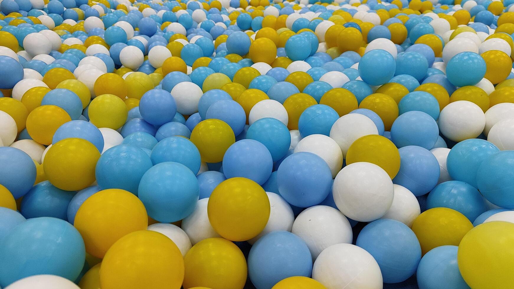 many blue and yellow balloons are arranged in a large pile photo