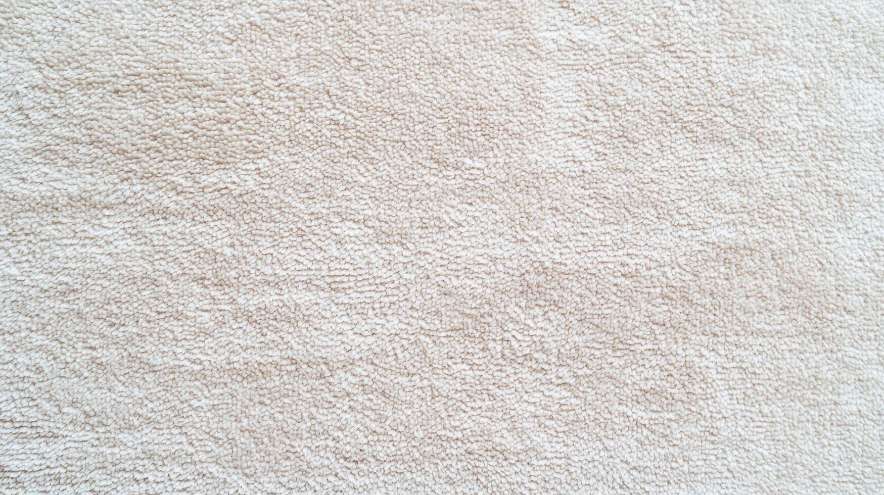 Soft beige towel fabric texture close up showing detailed loops and absorbent surface ideal for home textile and cleanliness concepts. photo