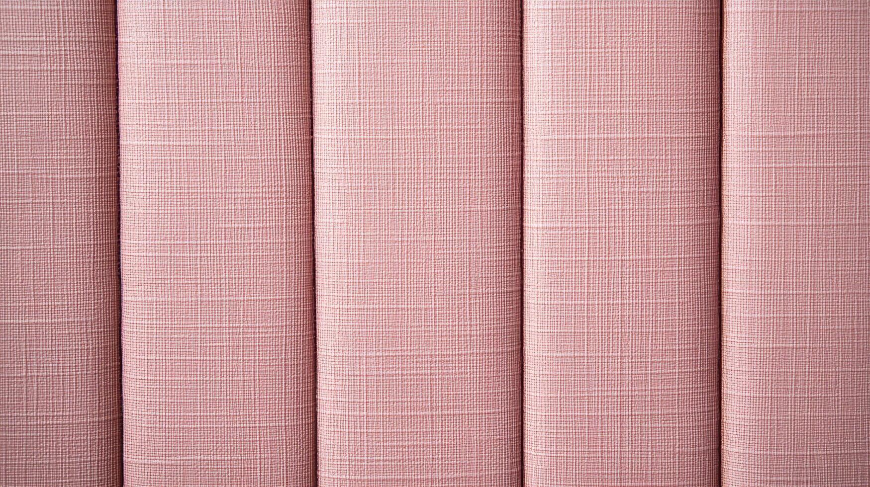 Close up view of pink upholstery fabric texture showing detailed textile weave and vertical pleats in soft lighting. photo