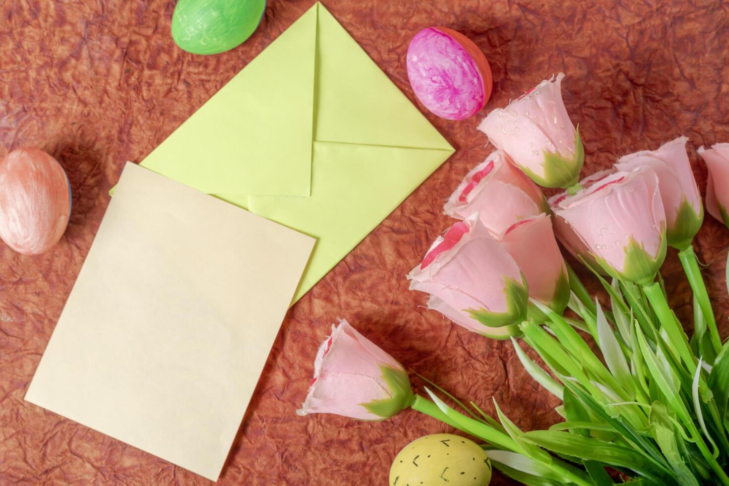 Colorful arrangement with pastel roses, Easter eggs and stationery. photo