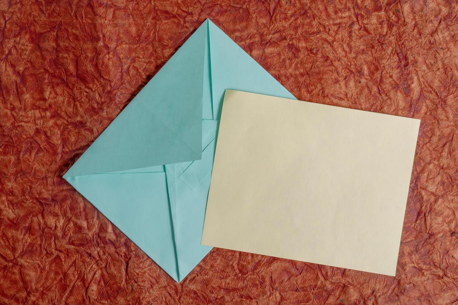 Blank stationery with envelopes on textured red background for invitation. photo