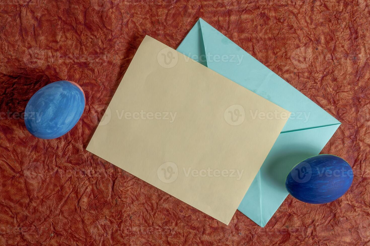 Blank card and envelope with Easter decorations on a red background photo