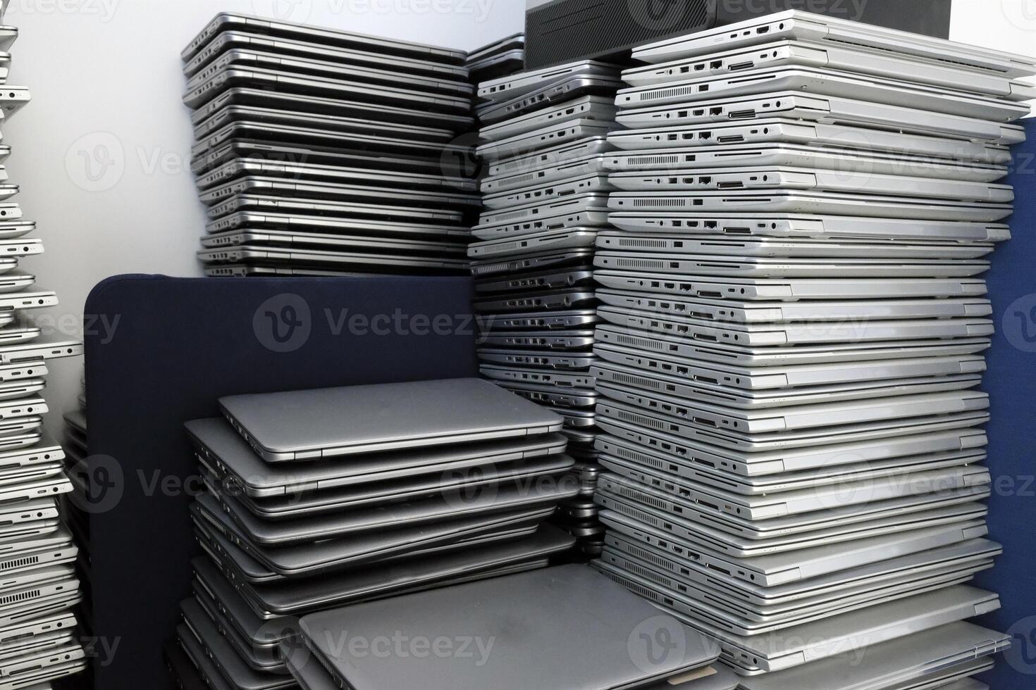 Multiple stacks of laptops in the storage room of a company photo