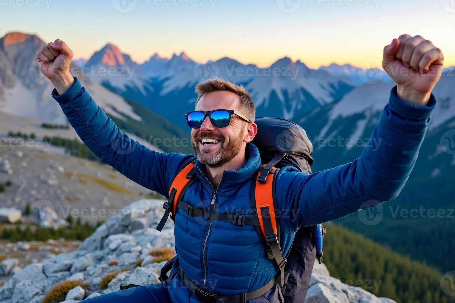 A man with a backpack and sunglasses sitting on top of a mountain photo