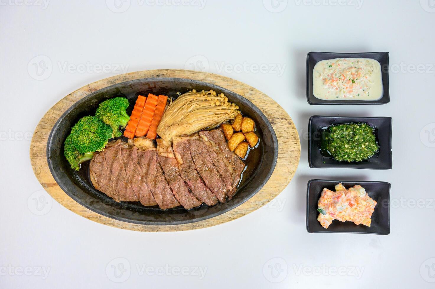 Japanese wagyu beef slices set with vegetables and sauce on wooden tray at table photo