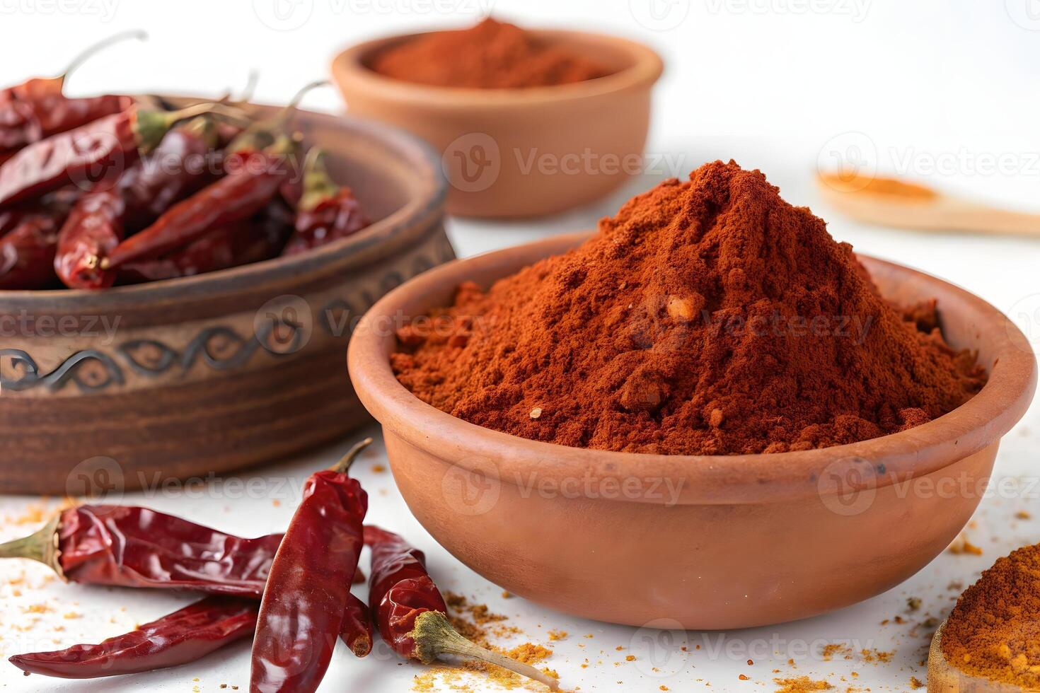 A bowl of chili powder and spices on a white table photo