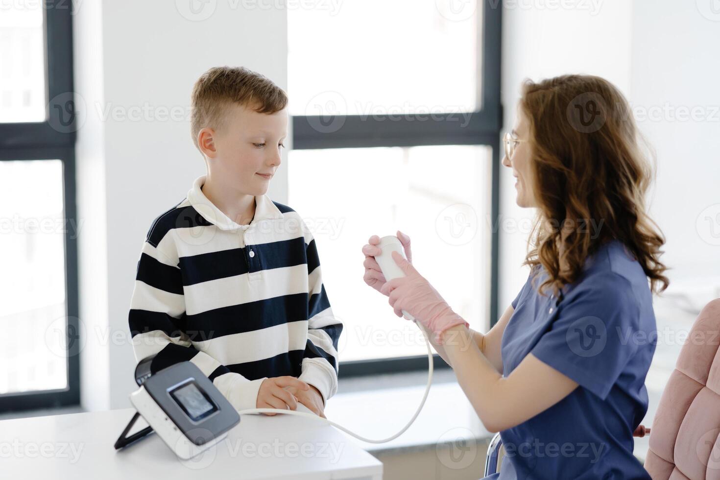 Boy testing breathing function by spirometry in doctors office. Diagnosis of respiratory function in pulmonary disease. photo