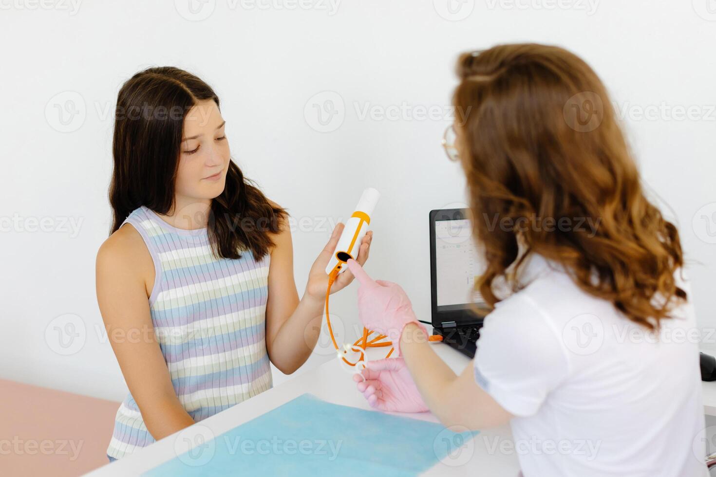 Girl testing breathing function by spirometry in office. Diagnosis of respiratory function in pulmonary disease. photo