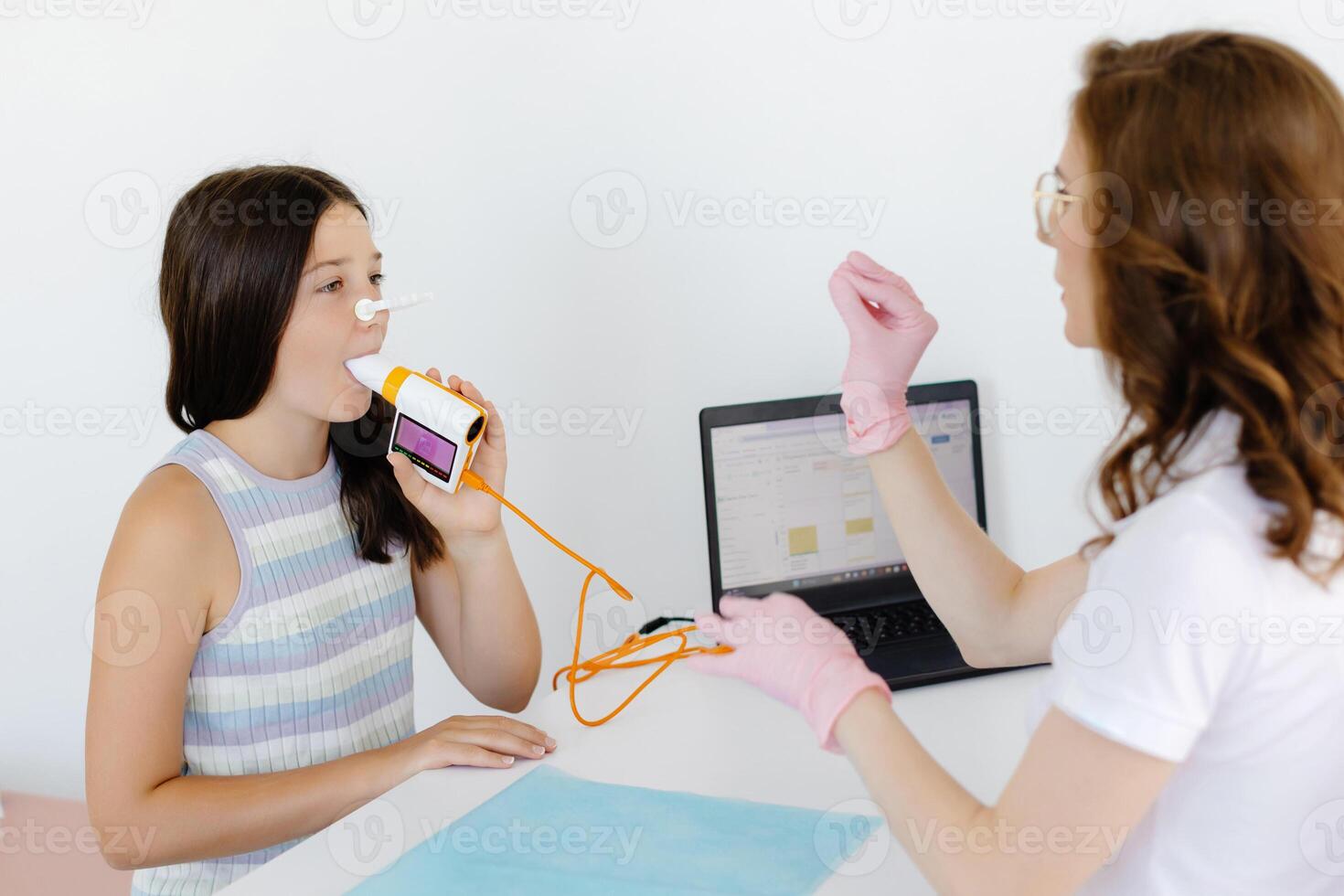 Girl testing breathing function by spirometry in doctors office photo