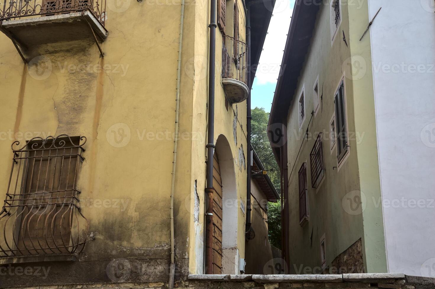 Alley between tall buildings seen from below photo