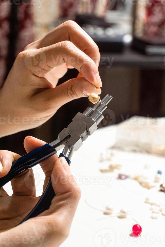 Hands of a person using round nose multipurpose pliers. photo