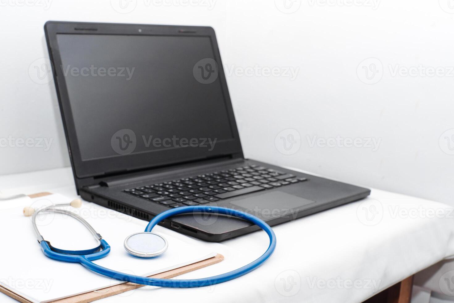 medical review chart next to a stethoscope next to a laptop with copy space. webinar concept of health and wellness and online medical consultation. photo