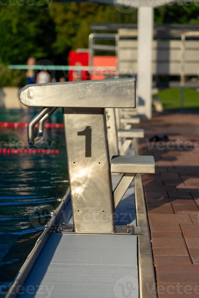 View of the starting blocks in the outdoor pool on a summer evening photo