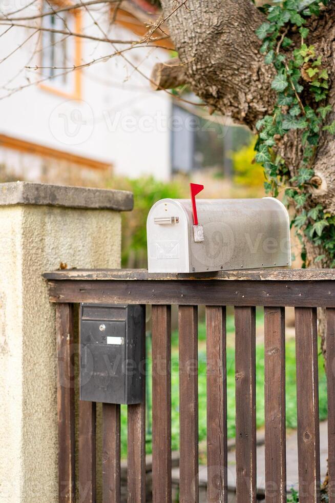 View of two different mailboxes installed on the fence of a private house photo