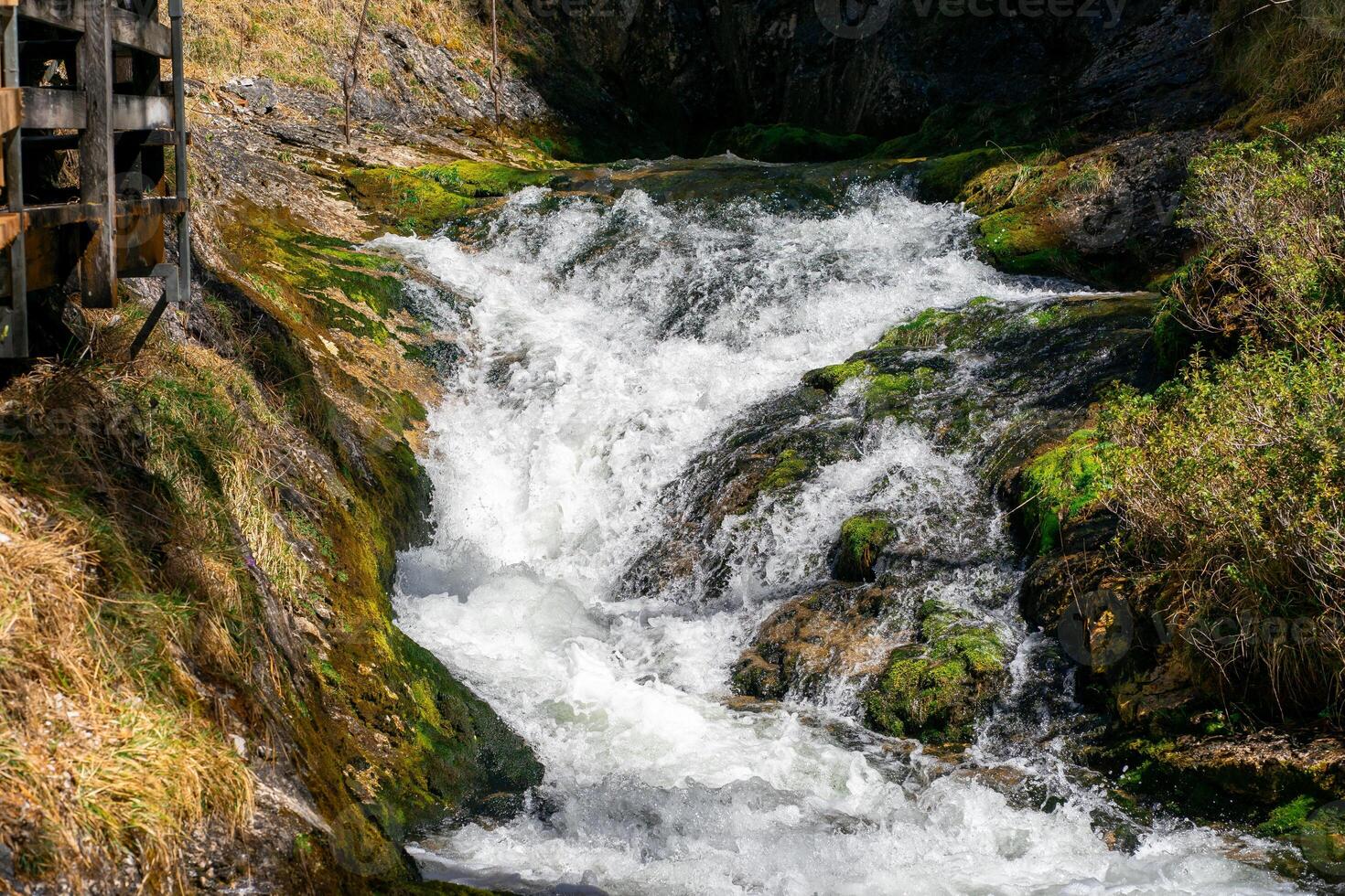 View of the cascades of a mountain river between the Alpine mountains photo